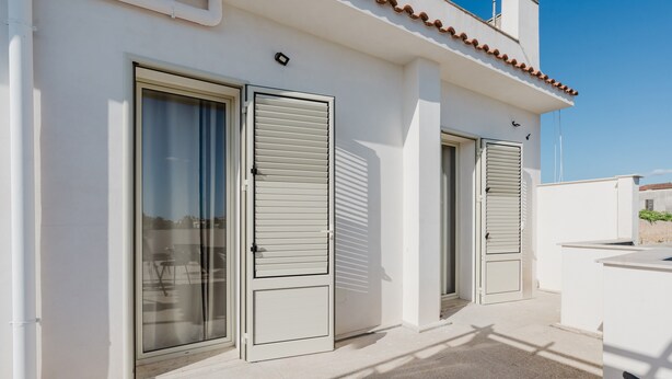A building with two doors, a tiled roof, and a clear sky. - Bed And Breakfast Champagneria 'Room 3' with Shared Terrace, Wi-Fi and Air Conditioning (Castelvetrano)