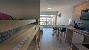 Una cocina moderna con zona de comedor, una litera y vistas a través de un ventanal.