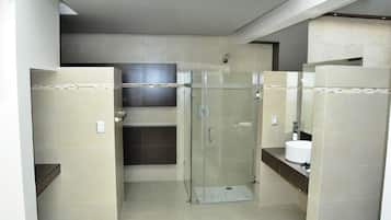 Un baño moderno con ducha de vidrio, lavamanos y retrete.