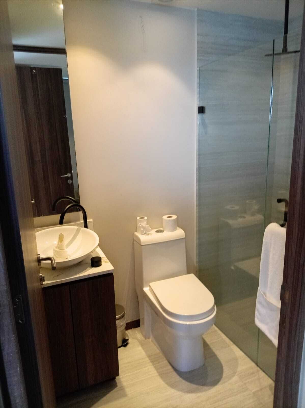 Ein modernes Badezimmer mit Waschbecken, Toilette und Duschkabine aus Glas.
