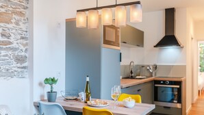 A modern kitchen with a dining table, chairs, and a potted plant. - Gustave - Proche centre-ville de Nantes (Nantes)