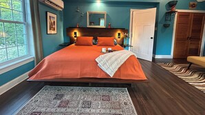 A bedroom with a large bed, a window, and a door. - Maine Coast Mountain Retreat (Camden)