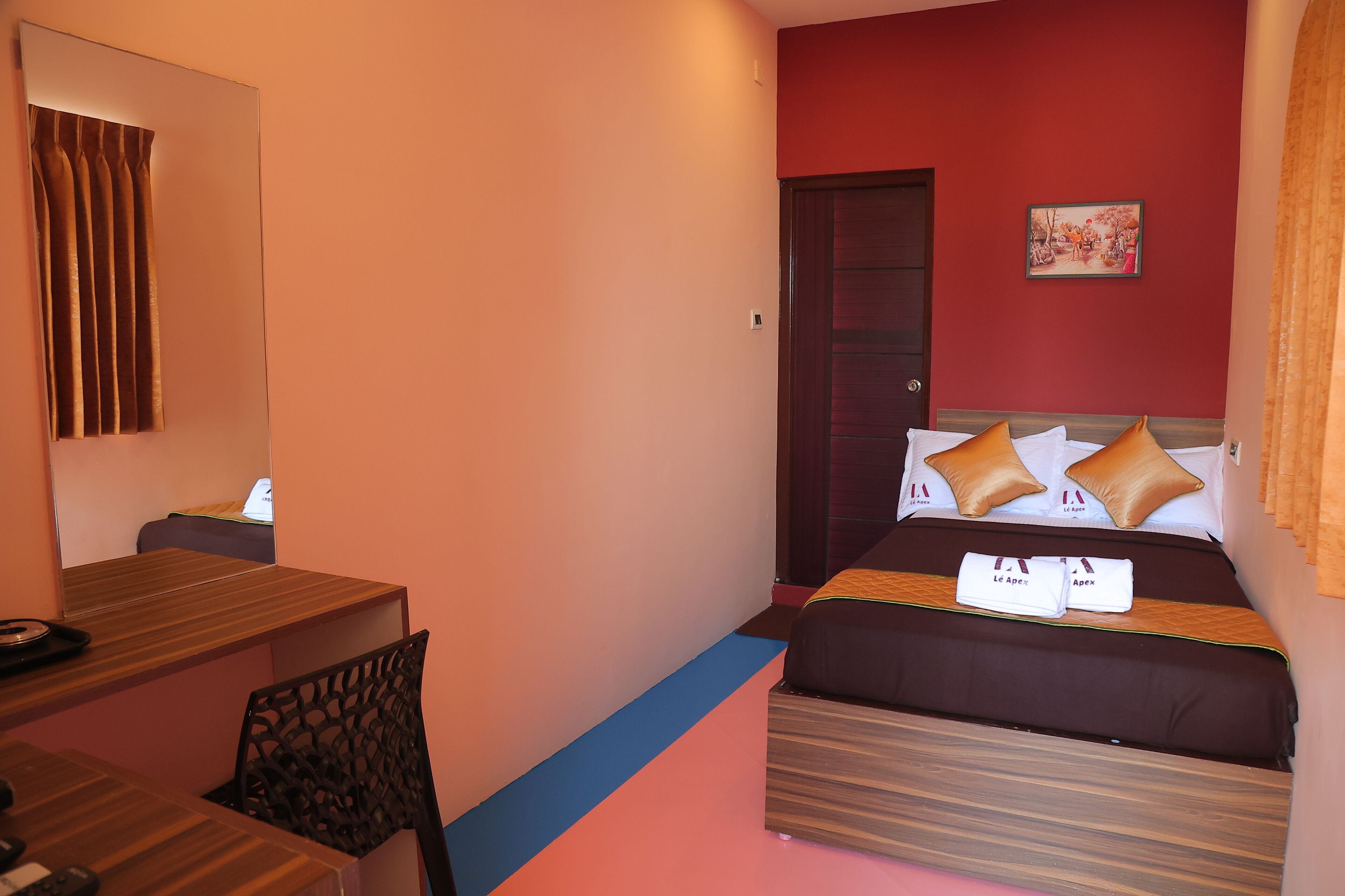 A hotel room with a bed, a desk, and a chair.