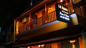 En byggnad med en skylt där det står ”Lé Apex Rooms & Dinners” och ett telefonnummer.