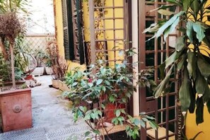 A narrow courtyard with potted plants and a small pathway. - Cottage Rome Centre (Roma)