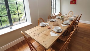 A dining room with a wooden table set for six, surrounded by wooden chairs. - The Old Creamery (Llandeilo)