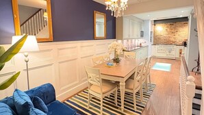 A modern kitchen with white cabinets, a brick accent wall, and a chandelier. - Stunning 4 Bed Town House w/ Roof Terrace in Farringdon / St Paul's Cathedral (London)