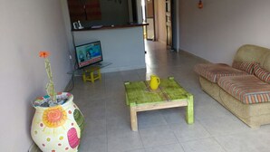 Un soggiorno con un divano, un tavolino e un vaso decorativo.