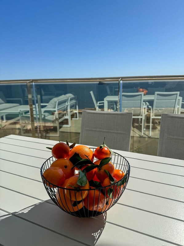 A white table with a wire basket containing oranges and leaves. - Sunset Cliffs Sea View (Benidorm)