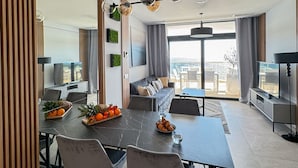 A modern living room with a dining area, large windows, and a view of the outdoors. - Sunset Cliffs Sea View (Benidorm)