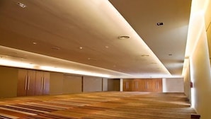 Ruime hotelkamer met houten vloer, inbouwkasten en in het plafond verwerkte verlichting.