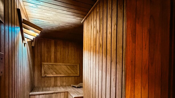 Een houten interieur met een schuine balkenlaag en een ingebouwde bank.