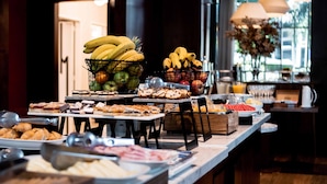 Een buffet met diverse gerechten, waaronder fruit, gebak en desserts.