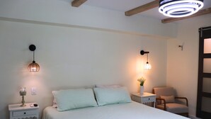 A bedroom with a bed, bedside tables, a chair, and wall-mounted lighting. - Harbor Side Retreat (Port Charlotte)