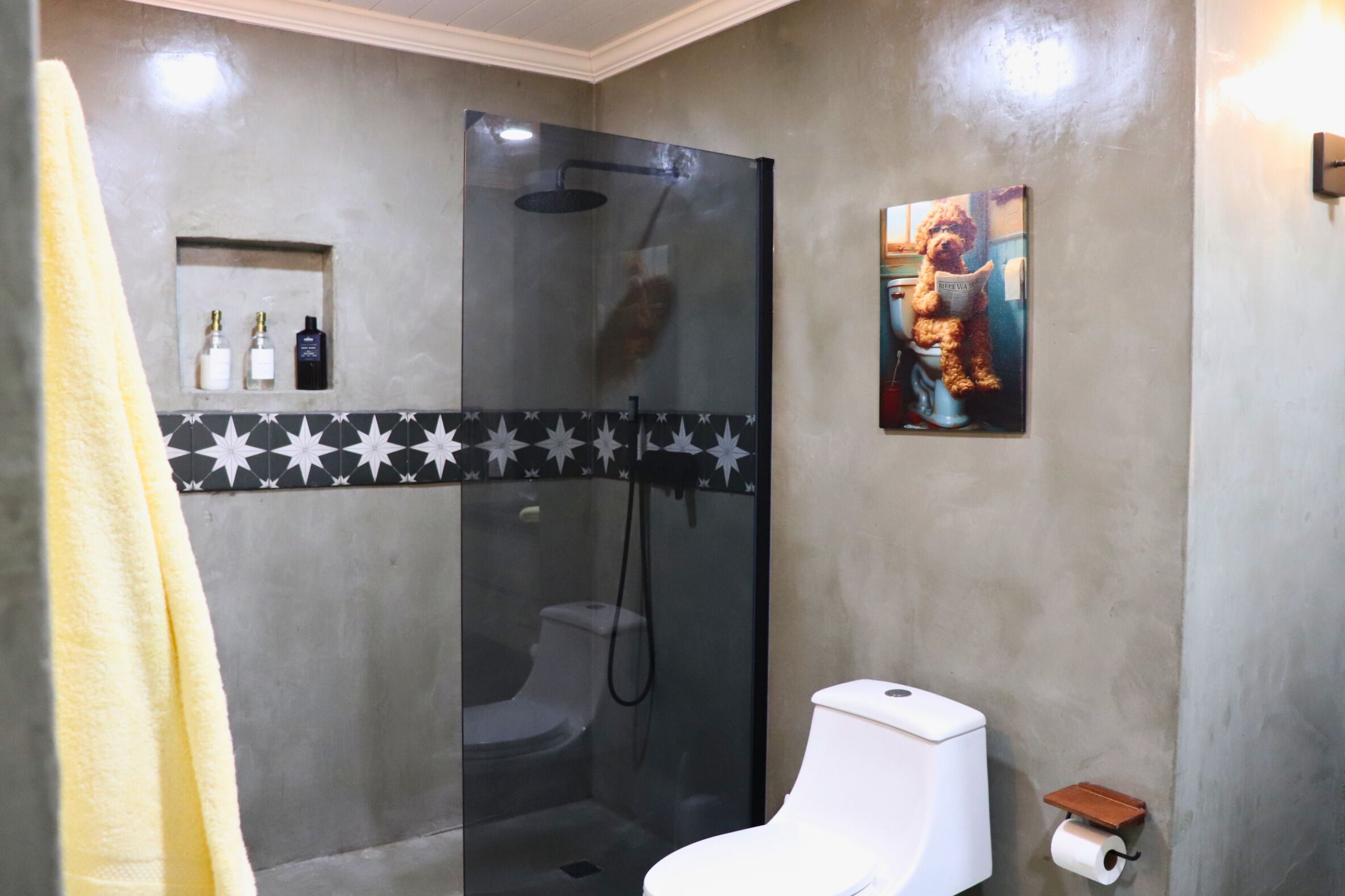 A bathroom with a glass-enclosed shower, a toilet, and a sink.