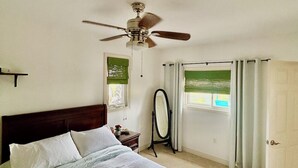 A bedroom with a bed, a ceiling fan, a window with curtains, and a door. - Stay at Jordan Valley Vineyards Barnhouse (Jordan Station)