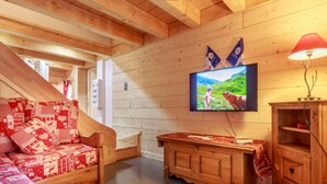 Un interior de madera con sofá, televisión y armario de madera.