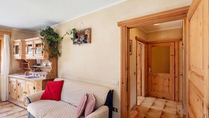 A cozy room with a bed, wooden cabinets, and a plant. - Apartment 'Di Bernardin' with Mountain View and Wi-Fi (Livigno)