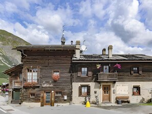 Un edificio rústico de madera con un balcón, una puerta y una ventana.
