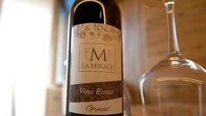 A bottle of wine with a label that reads 'Vino Rosso' and 'LA MIRAGE.' - Apartment 'La Mirage' with Mountain View, Balcony and Wi-Fi (Livigno)