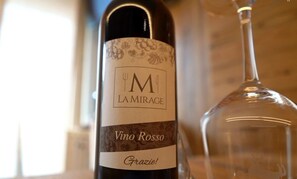 Une bouteille de vin dont l’étiquette porte les inscriptions « Vino Rosso » et « LA MIRAGE ».