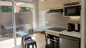 Una cocina moderna con un ventanal grande, horno empotrado, microondas y cafetera.