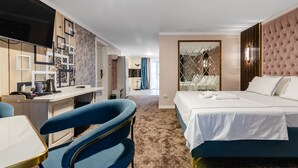 Una camera d'albergo con un letto, una scrivania, una sedia e una TV.