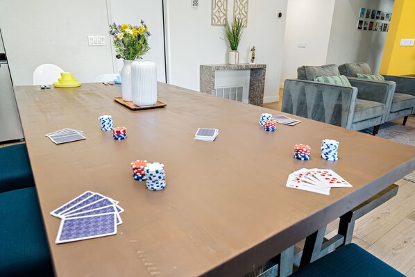 Une table de conférence ornée de jetons de poker, de jeux de cartes et d’un vase rempli de fleurs.