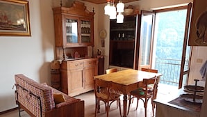 Un coin repas accueillant avec une table et des chaises en bois, un canapé et un meuble avec des portes en verre.