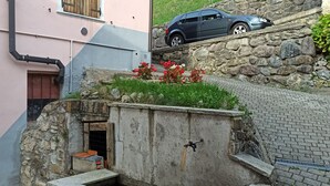 Un bâtiment rose avec une voiture garée sur un escalier en pierre.