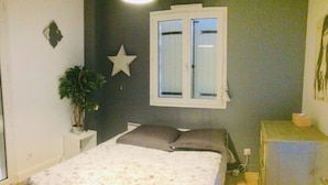 A bedroom with a bed, a window, a star decoration, a plant, and a cabinet. - House with pool near Montpellier Plage July 12-August 2 (Le Crès)