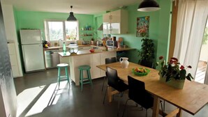 A kitchen with a wooden table, chairs, a refrigerator, and a window. - House with pool near Montpellier Plage July 12-August 2 (Le Crès)