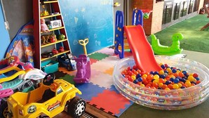 A children's play area with toys, a slide, and a ball pit. - Pousada Enseada São Miguel (Penha)