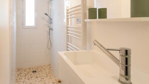 Une salle de bain moderne équipée d’une douche, d’une baignoire et de toilettes.