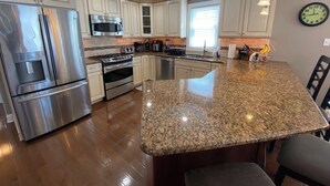 Una cocina moderna con electrodomésticos de acero inoxidable, encimeras de granito y una isla grande.