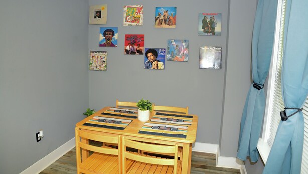 A dining area with a wooden table, chairs, and a potted plant.