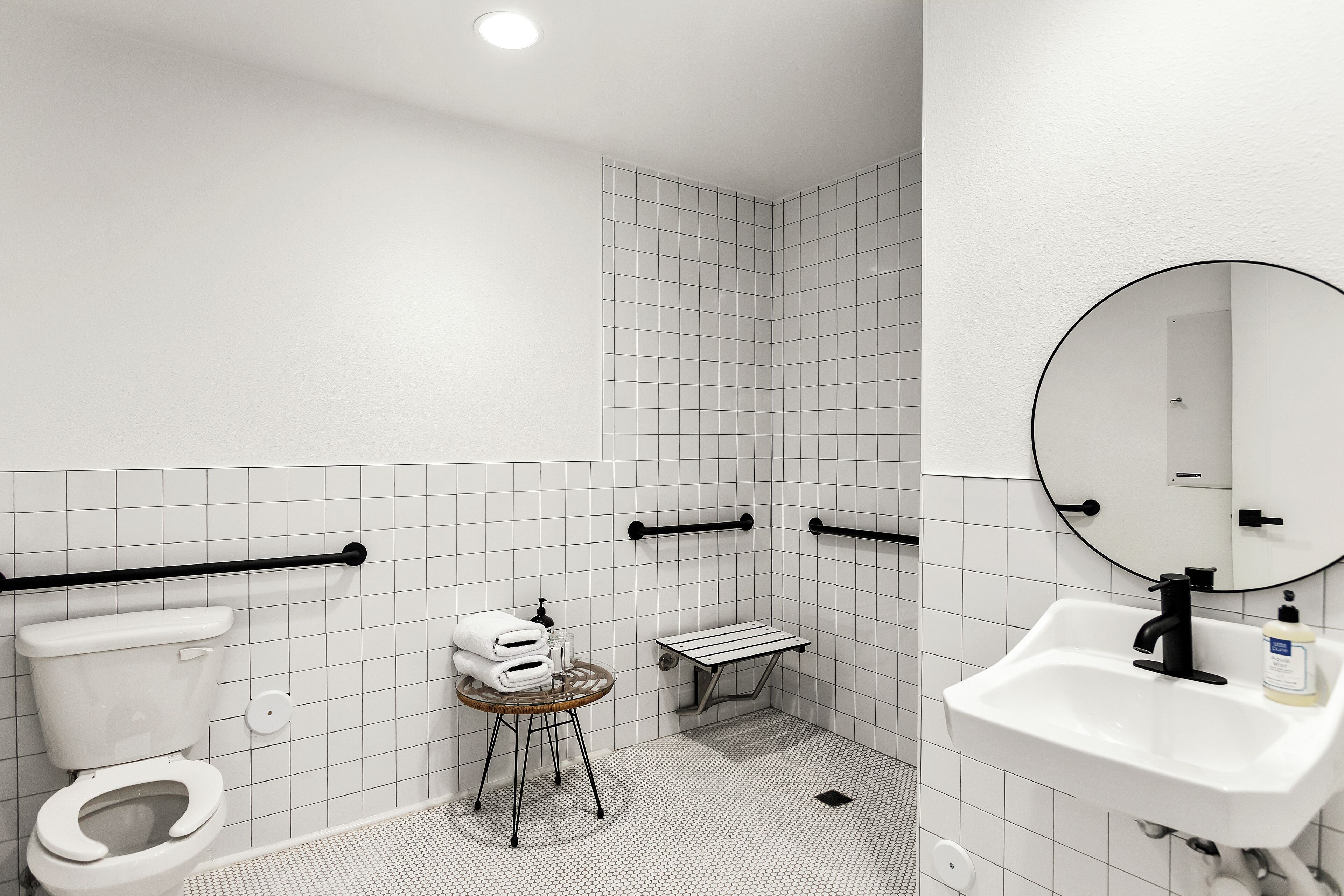 A modern bathroom with a toilet, sink, and shower area.