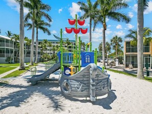 A playground with a slide, climbing structures, and a ship-themed play area.