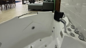 Un bagno moderno con una vasca da bagno grande, una doccia e un water.