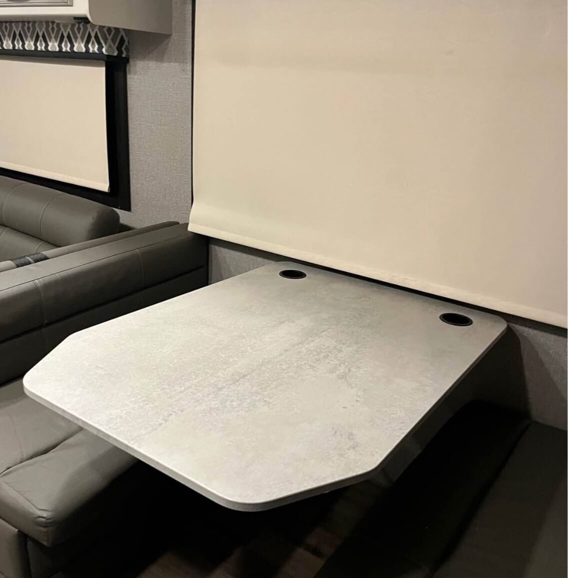 Un espacio habitable compacto con un sofá, una mesita y una pizarra en la pared.