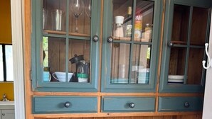 A teal-colored wooden cabinet with glass doors, wooden shelves, and drawers. - The Well House with outdoor seating and loft! (Middletown)