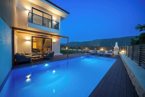 A modern two-story house with a swimming pool, outdoor seating, and a view of the mountains. - Kas Pera Villas (Kaş)