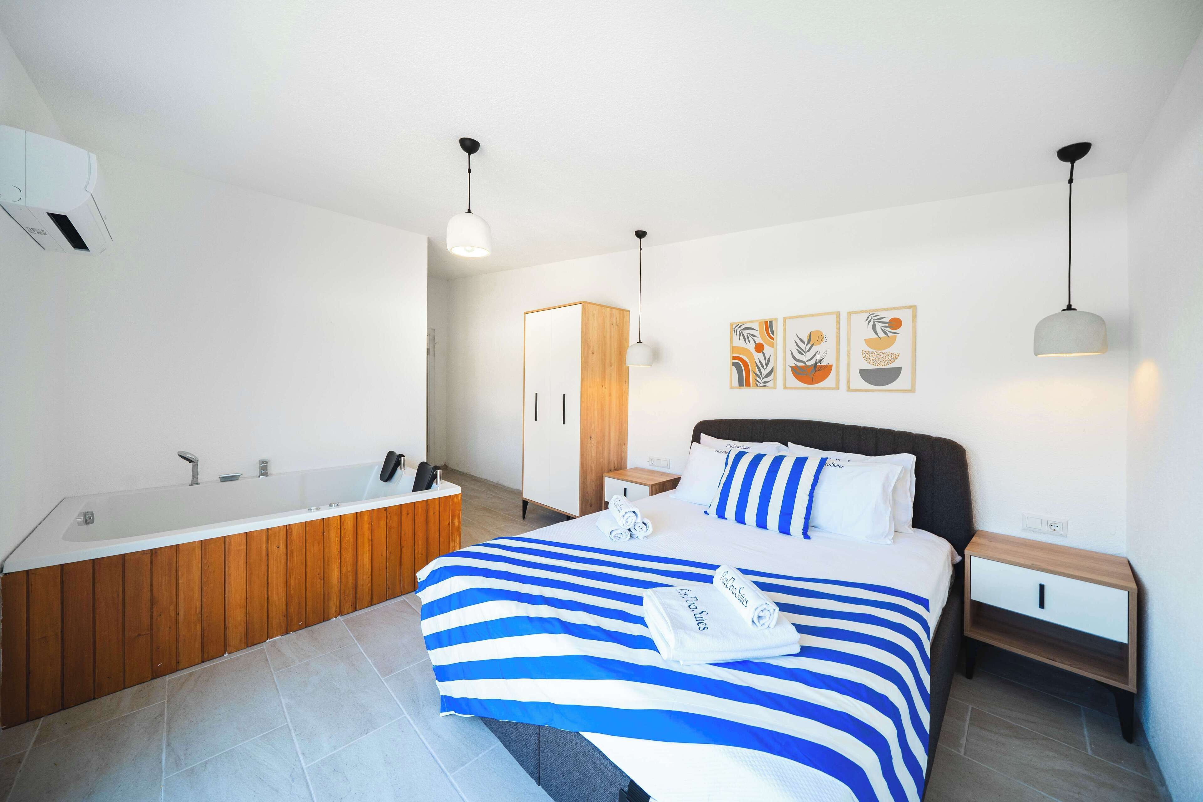 Un dormitorio moderno con una cama grande, un tocador de madera, una bañera y una mesita de noche.