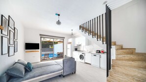 Ein modernes Wohnzimmer mit einer Couch, einem Essbereich und einer Küche.