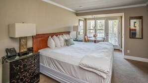 Une chambre à coucher avec un grand lit, des tables de chevet, un bureau et une chaise.