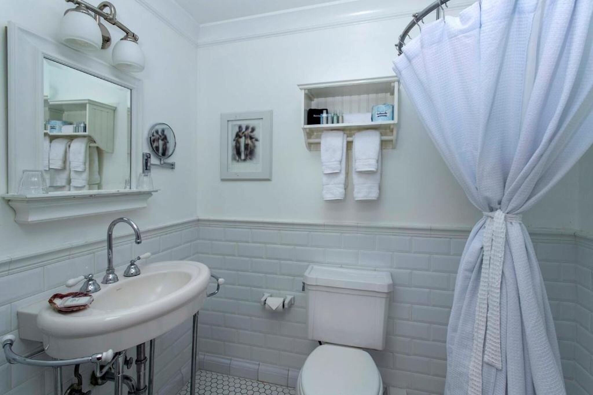 Freshen up in a classic bath with bright lighting and clean lines
