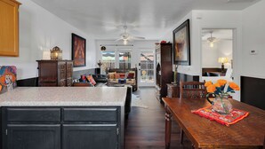 Amplia sala de estar con cocina, mesa de comedor y vistas al exterior.