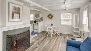 Ein geräumiges Wohnzimmer mit Kamin, Essbereich und einer Küche im Hintergrund.