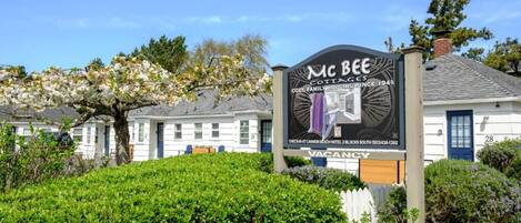 A sign for Mc Bee Cottage, indicating it is a cozy family lodging since 1941, with a vacancy notice.