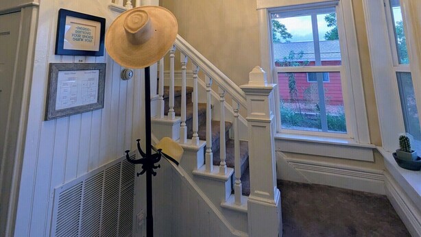 A staircase with a chandelier, framed certificates, and a vent. - Spacious Victorian-Style Family Retreat | 5 Ensuite Bedrooms + Event-Ready Yard (Kanab)